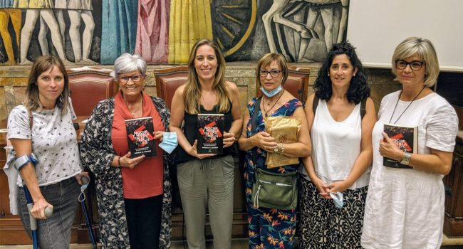 Mónica G. Álvarez (en el centro con el libro), junto a las familiares de Elisa Garrido -Laura Lázaro, Pilar Gimeno (a la izquierda), Mayte Lázaro e Isabel Gimeno (a la derecha) y la diputada Elena García, en la presentación del libro ‘Noche y Niebla en los campos nazis’. Foto: Iker G. Izagirre (AraInfo)