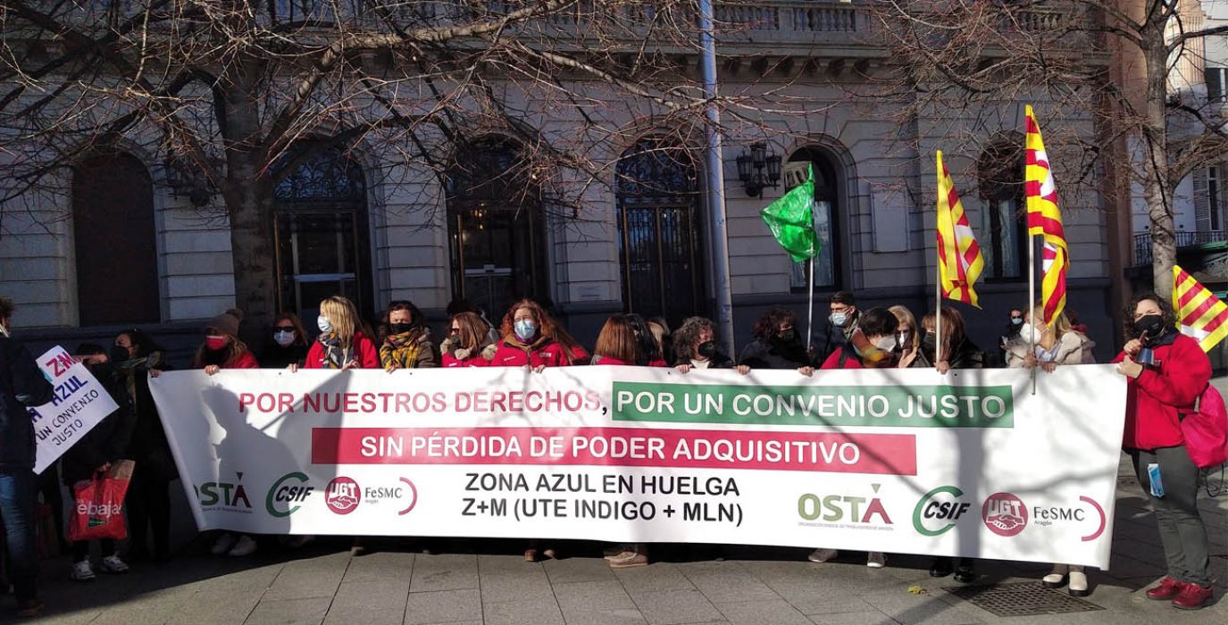 un grupo de personas concentradas con una pancarta durante este conflicto laboral