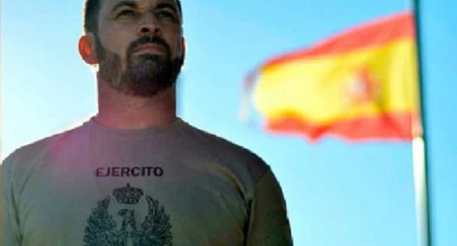 Santiago Abascal, líder del ultraderechista Vox, posando con bandera y camiseta prestadas.