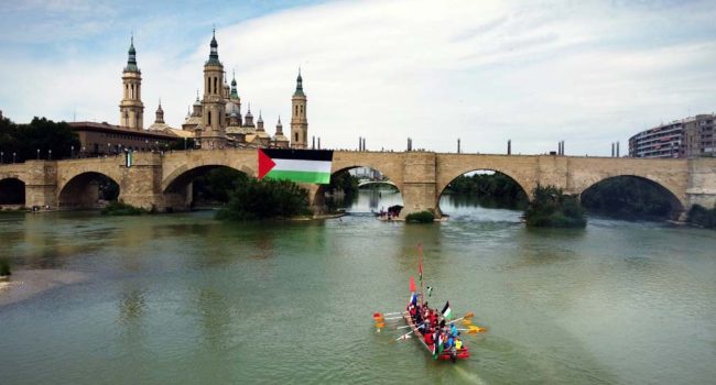 Fotografía del simbólico paseo en barcas en el Ebro a su paso por Zaragoza. | Foto: Casa Palestina de Aragón
