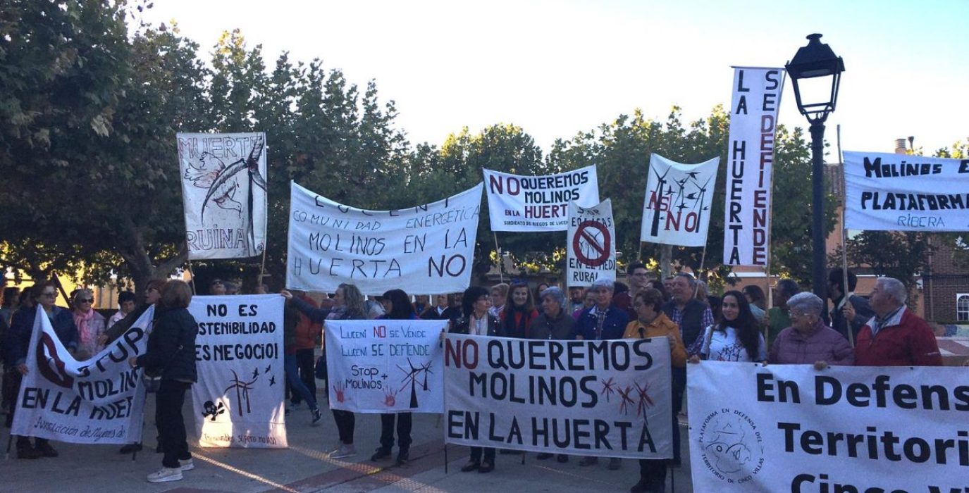 varias personas con carteles en una concentración en contra de los aerogeneradores