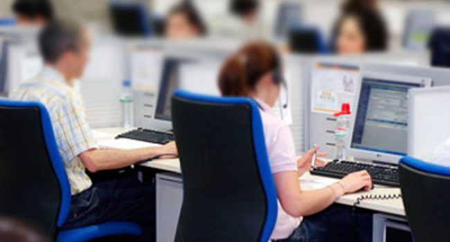 oficina de un contact center con varias personas trabajando cada una con su ordenador