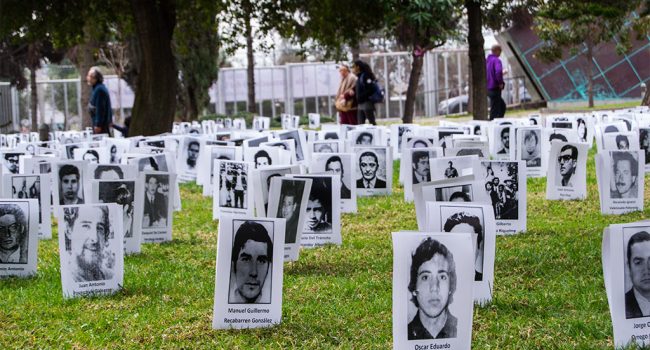 Retratos en blanco y negro de ejecutados y desaparecidos durante la dictadura chilena expuestos en el Parque por la Paz Villa Grimaldi durante la conmemoración del Día del Detenido Desaparecido. Foto: Adrián Solana Mayayo