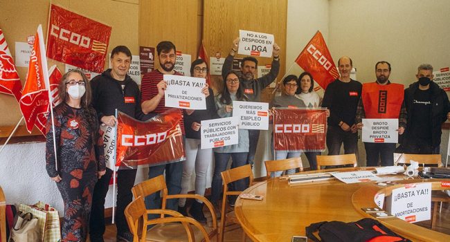 Un grupo de sindicalistas con pancartas en una sala de reuniones