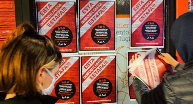 Activistas pegan carteles en una sucursal de ‘Alquiler Seguro’