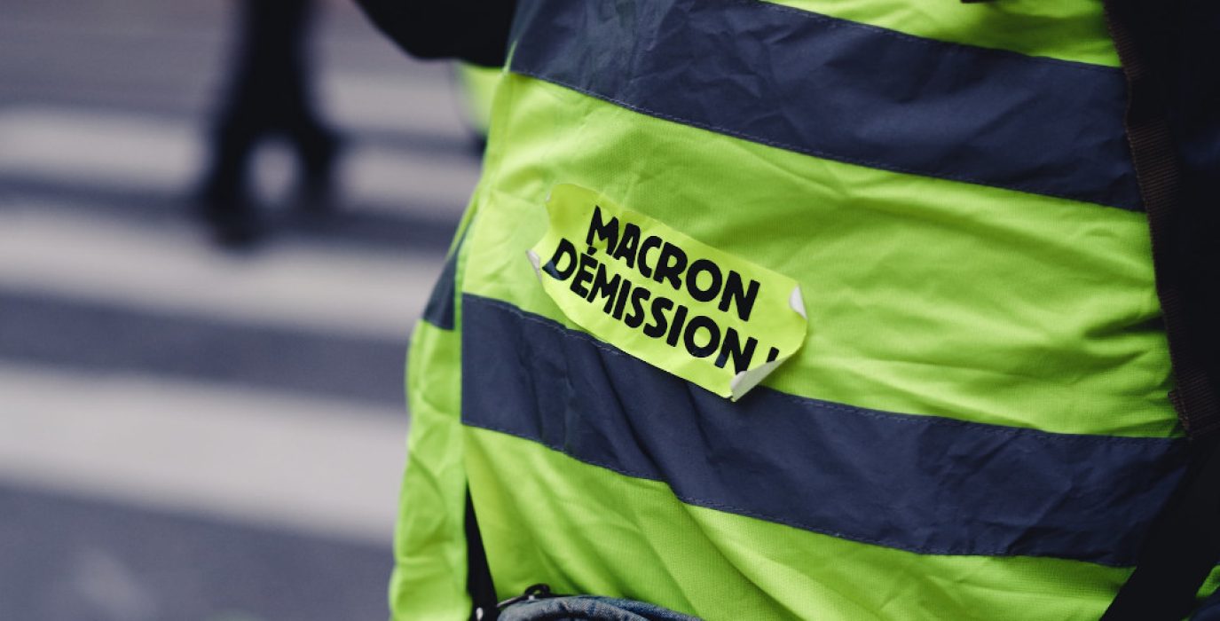 Un chaleco amarillo donde se lee 'Macron dimisión' en francés en una marcha de la izquierda francesa