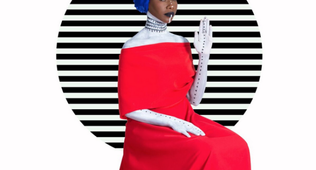 Fatoumata Diawara sentada con un vestido rojo y un pañuelo azul en la cabeza