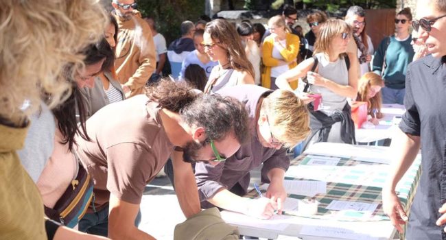 Vecinos y vecinas de Benás firman en las mesas colocadas durante la movilización en la localidad el pasado 13 de octubre