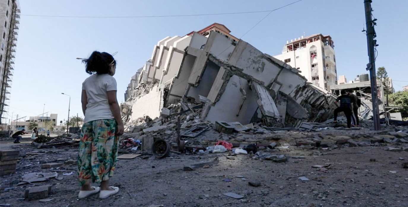 Una niña mira la torre Hanadi destruida tras una serie de ataques aéreos israelíes contra Gaza el 12 de mayo de 2021. Foto: UNRWA