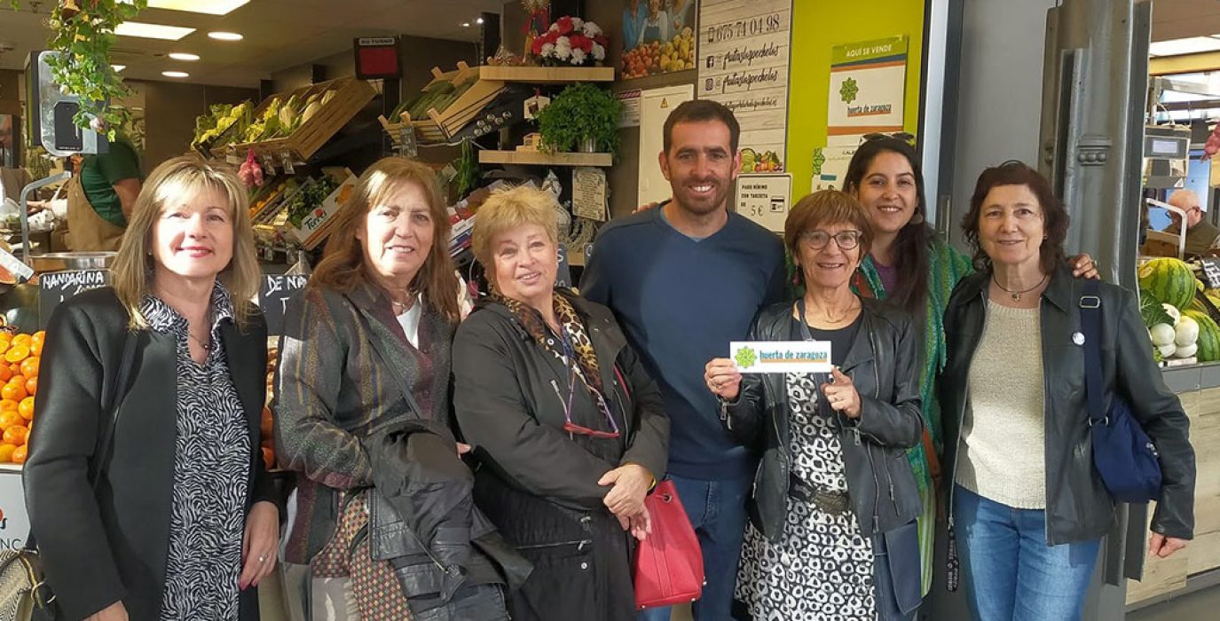 varias personas posando con la etiqueta huerta de zaragoza