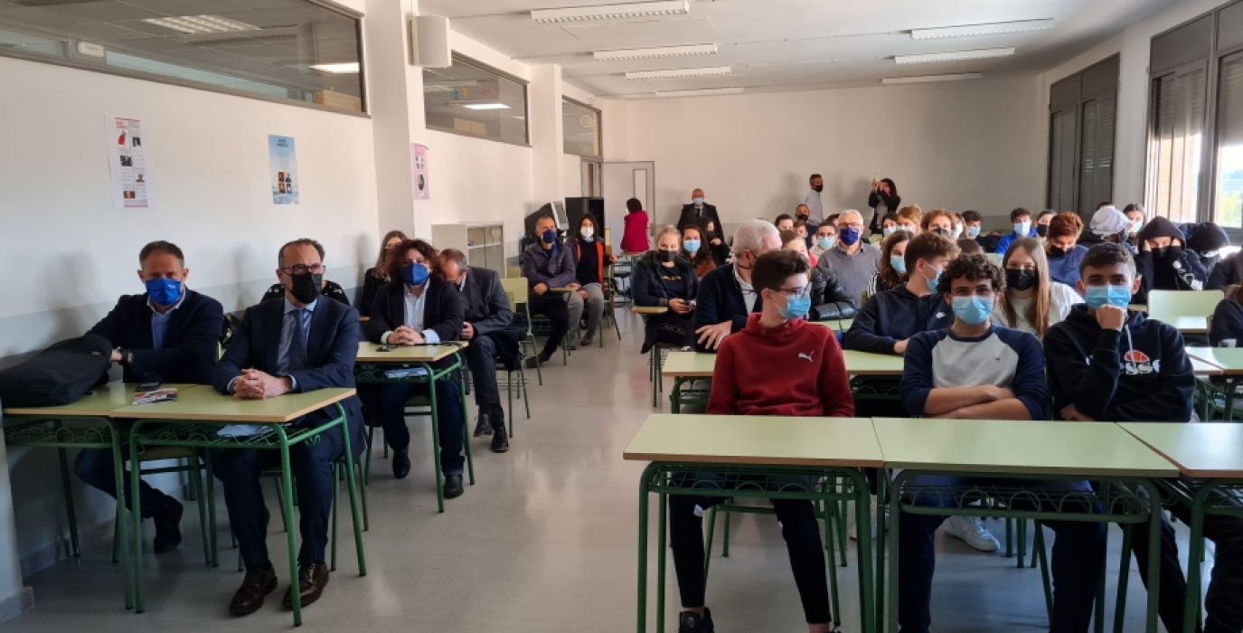 Felipe Faci sentando entre el alumnado durante una visita a un IES