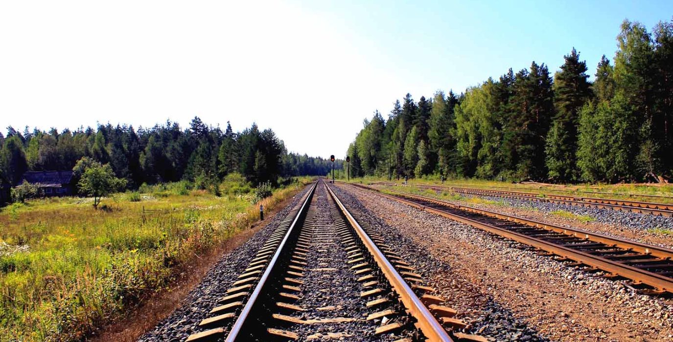 Una vía de tren rodeada a verde