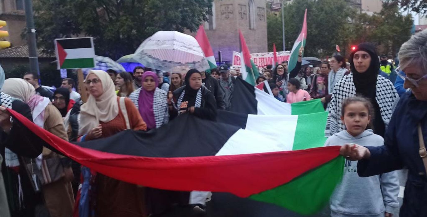 Un grupo de manifestantes sostiene una bandera palestina de gran tamaño en la marcha de Zaragoza. | Foto: AraInfo