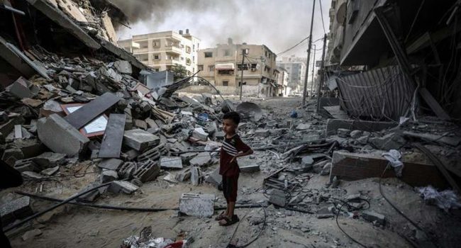 Foto de archivo de un niño que mira la destrucción causada por las bombas en su barrio de Gaza. | Foto: UNRWA