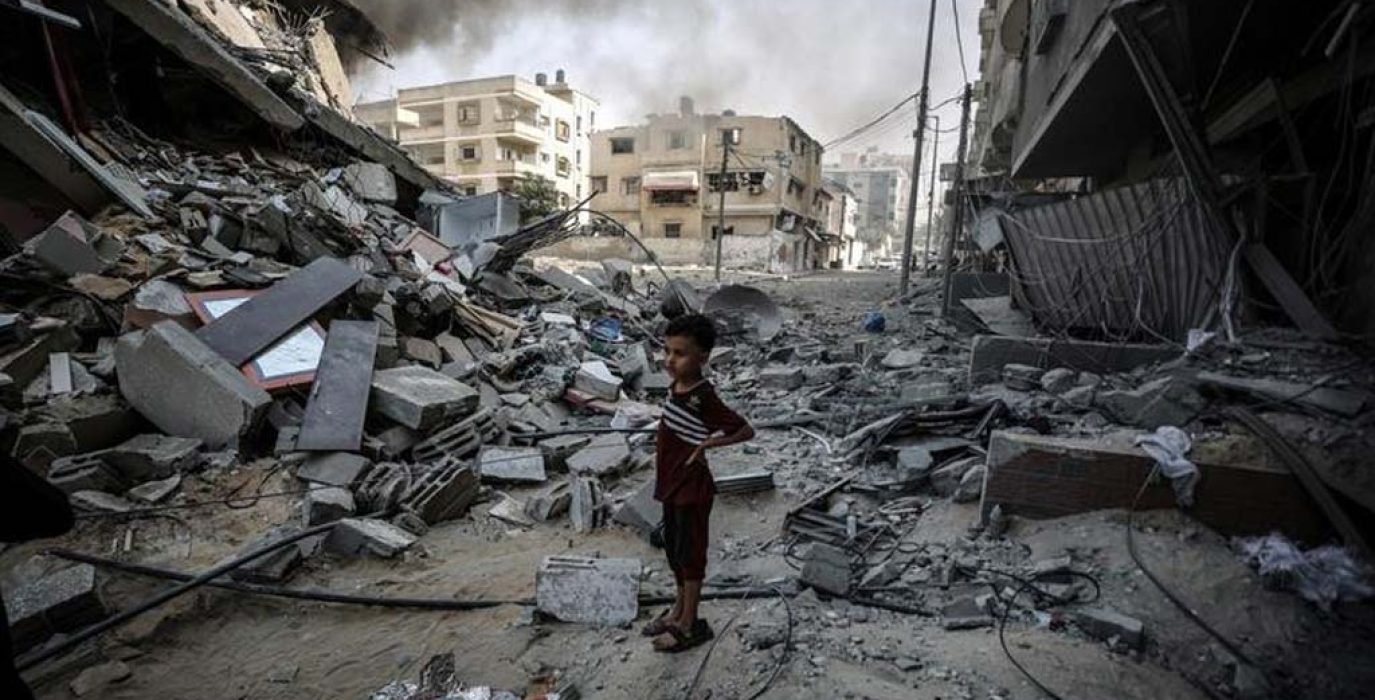 Foto de archivo de un niño que mira la destrucción causada por las bombas en su barrio de Gaza. | Foto: UNRWA