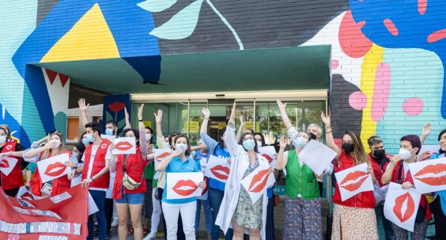 un grupo de personas frente al hospital con carteles de besos
