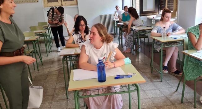 Unas personas en un aula presentándose a una oposición
