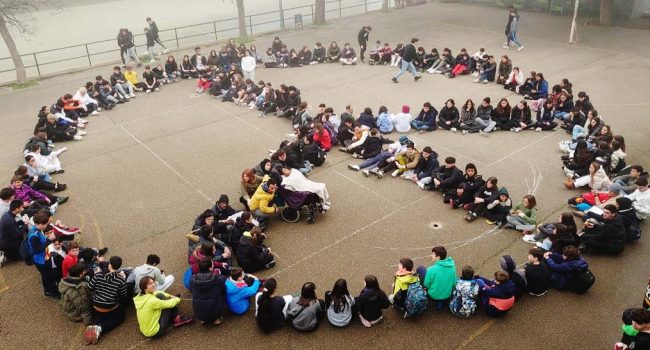 Estudiantes formas el símbolo de la paz en un patio escolar. | Foto: Docentes con Palestina