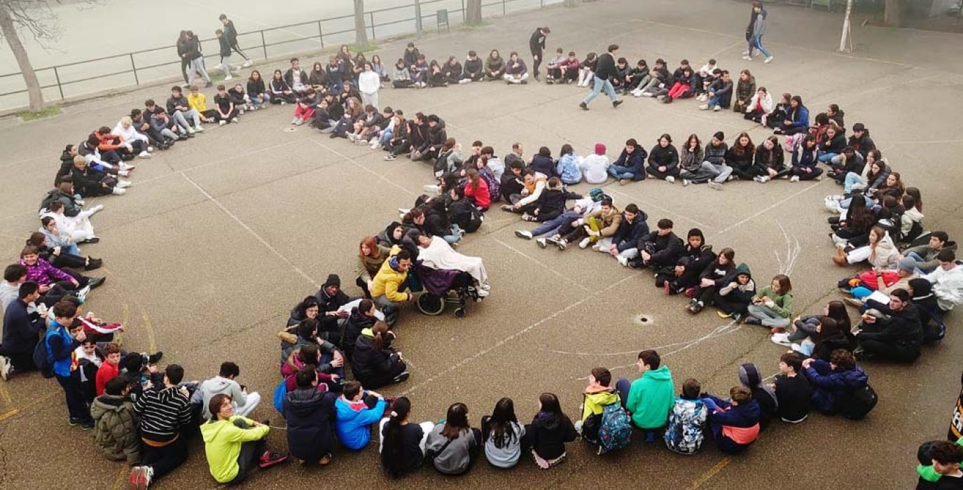Estudiantes formas el símbolo de la paz en un patio escolar. | Foto: Docentes con Palestina