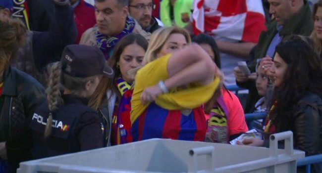 Una mujer se desprende de una camiseta amarilla a instancias de la policía.  Foto: TV3.