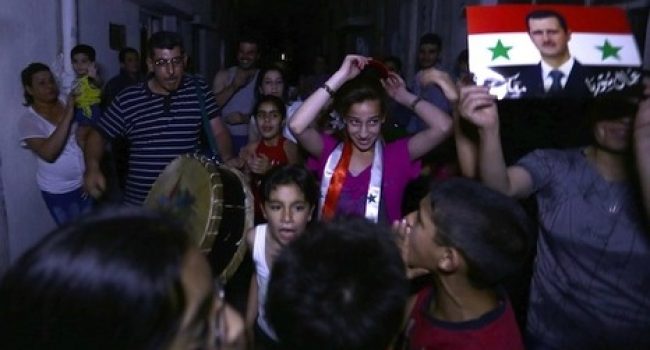 Varios ciudadanos festejan en las calles la victoria de Al-Assad. Foto: Louai Beshara
