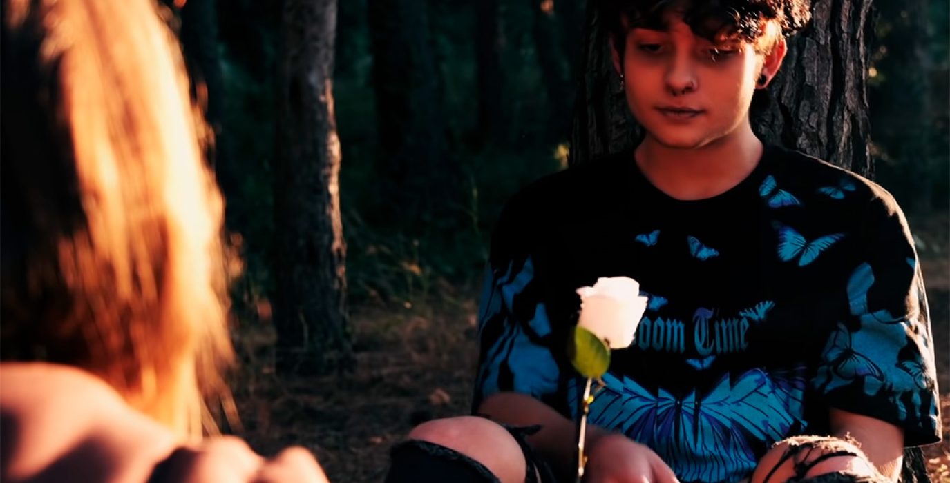 una niña le da una flor blanca a otra persona suicidio