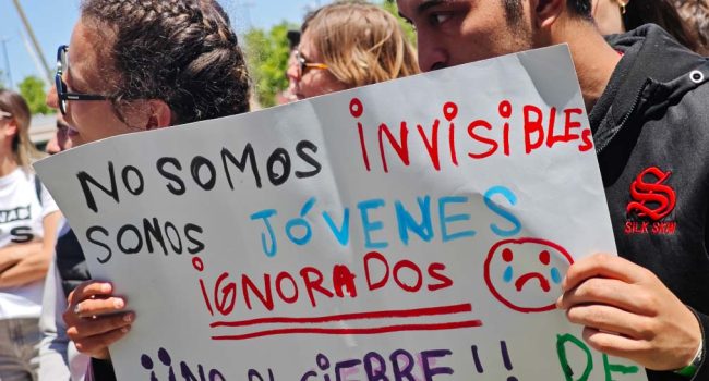 Jóvenes sostienen un cartel en una protesta contra los recortes de las Zonas Jóvenes en mayo de 2025. | Foto: Pablo Híjar, AraInfo